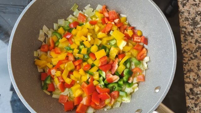 Colorful chopped peppers and leeks sizzling in a wok