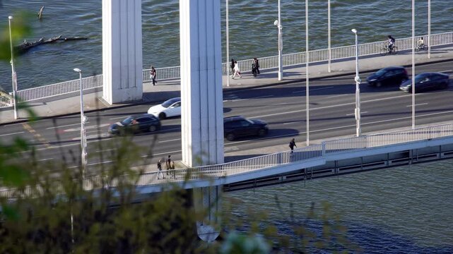 Close up aerial drone video of a white bridge in Budapest, showcasing modern infrastructure, transportation connectivity, and mobility across urban and natural landscapes.