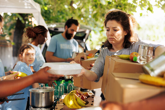 Diverse group provides aid, handing out meals to poor and needy individuals, with volunteers of all backgrounds come together to help the homeless, offering support through a charitable food drive.