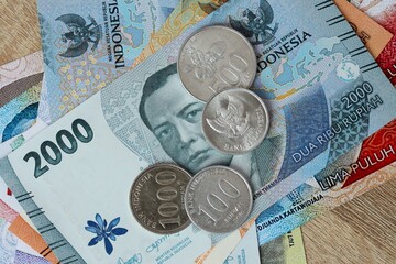 Indonesian rupiah money bills and coins on table. Indonesia cash of IDR currency © Larysa