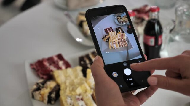 young woman creates content for social media. films food with mobile phone.