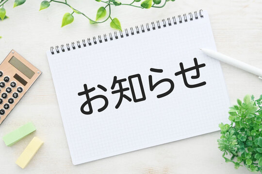 ノートに書かれた「お知らせ」の文字とビジネスイメージ