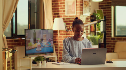 African American worker begins work day at home workstation, starting to solve daily tasks at...