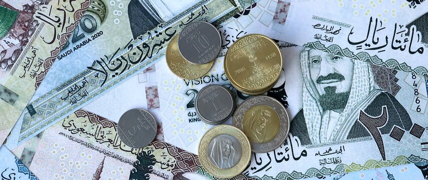 Saudi riyal money bills and coins in pile. Big amount of Saudi Arabia SAR currency cash close up