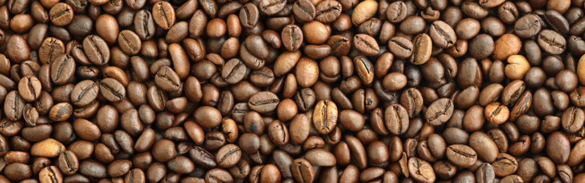 Detailed view on brown roasted coffee beans in big pile on table close up
