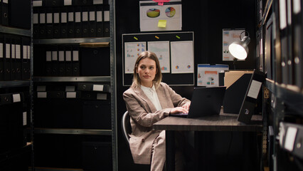 Confident female private detective investigator reviews clues in office, searching on laptop for evidence to solve crime, profile portrait of focused Caucasian policewoman using personal computer. © DC Studio