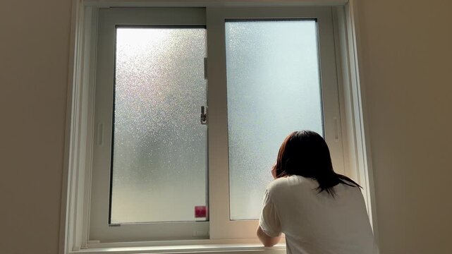 窓の外を眺める女性