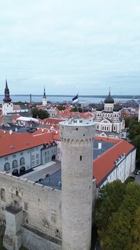 View of Tallinn's Old Town with towers, rooftops, and flag from a tower in Estonia during daytime.Tall Hermann is the defensive tower standing at the southwestern corner of Toompea Castle in Tallinn.