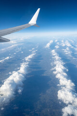 Obraz premium Airplane wings extend above white clouds, providing clear view of atmospheric layers and sense of altitude during the flight, air transportation