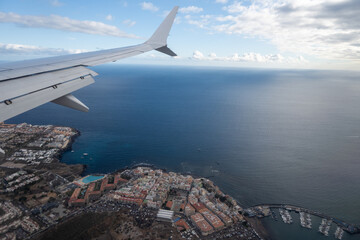 Obraz premium Airplane wings during landing on Tenerife, Canary islands, providing clear view of atmospheric layers and sense of altitude during the flight, air transportation