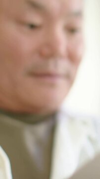 Vertical video: Camera panning, gray man holding note, reading then scanning home in robe recalling