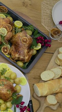 Vertical video: Sweeping camera showing table at home with roast chickens, napkins, bread for meal