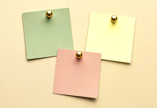 Three colorful sticky notes pinned to a textured surface, flat lay composition