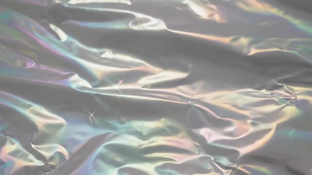 Shimmering Iridescent Texture of Crumpled Holographic Metallic Foil with Rainbow Light Reflections, Ideal for Modern Fashion Backgrounds.