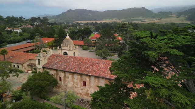 Drone aerial footage of the historic Mission Basilica in California, showcasing its iconic Spanish colonial architecture, church complex, courtyards, and surrounding urban landscape