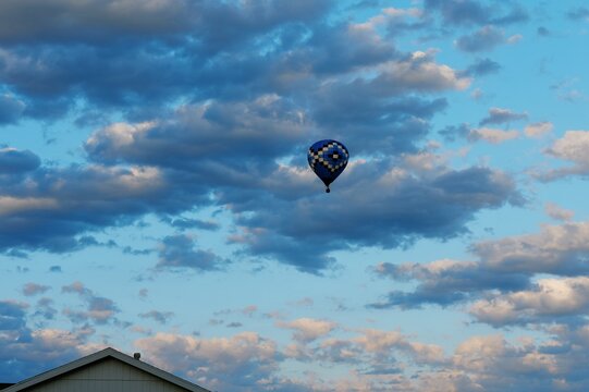 Blue checkered pattern hot air balloon flying high cloudy sky background conceptual freedom cloud computing data tracking growth travel adventure