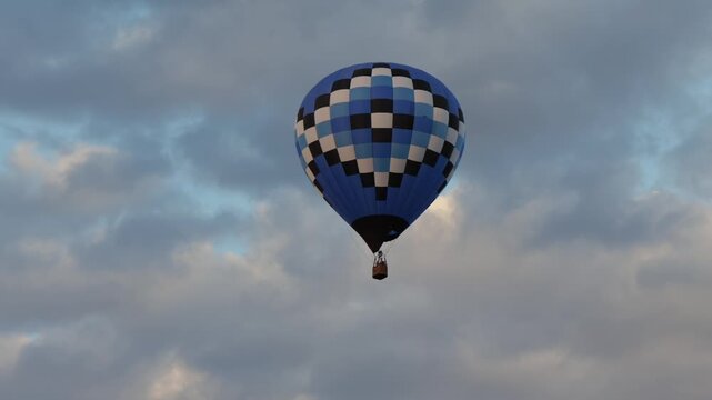 Blue checkered pattern hot air balloon flying high cloudy sky background conceptual freedom cloud computing data tracking growth travel adventure
