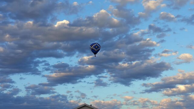 Blue checkered pattern hot air balloon flying high cloudy sky background conceptual freedom cloud computing data tracking growth travel adventure