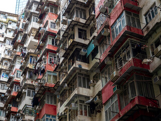 Fototapeta premium Close up of the famous Monster Building residential complex in Hong Kong. Dense stacked apartments with air conditioners and windows represent extreme urban density and iconic megacity architecture.