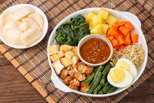 Gado-gado is a food consisting of vegetables, potatoes, tempeh, tofu, boiled eggs, etc. seasoned with peanut sauce and so on.
