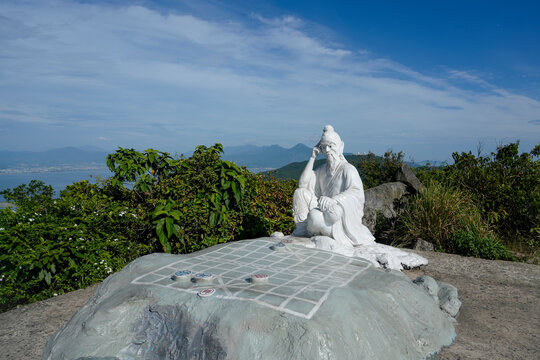 Statue of the deity sitting by chess board on Ban Co Peak on Son Tra peninsula by Da Nang city, Vietnam. Popular tourist spot leading trail in the mountains hiking trekking climb