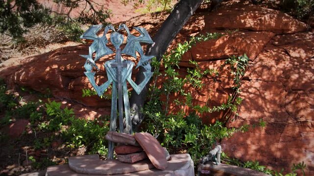 Metal Prayer Wheel Sculpture Against Red Rock Formation in Sedona