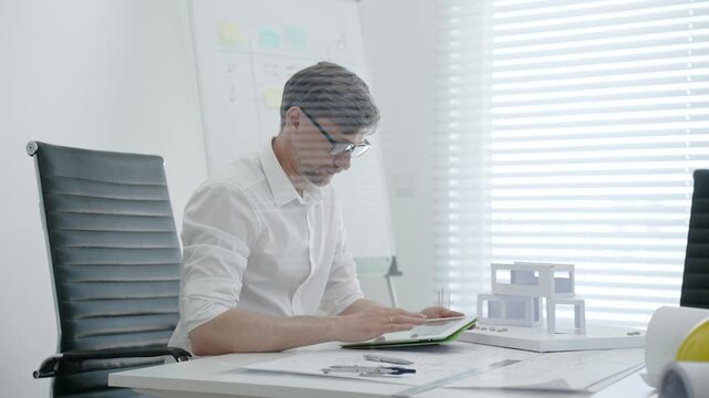 Architect designing residential building model in office, creating detailed blueprints and plans for urban development, focusing on construction project planning and creative architectural solutions