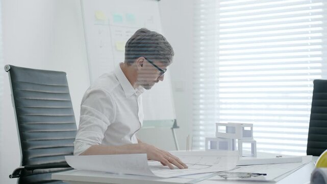 Architect designing residential building model in office, creating detailed blueprints and plans for urban development, focusing on construction project planning and creative architectural solutions
