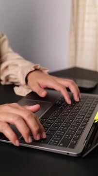 Unrecognizable businesswoman typing on laptop at home, representing remote work, freelancing, online communication, email management, web browsing, and digital productivity.
