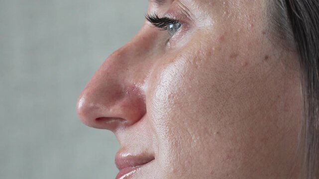 Woman face skin texture, close-up profile view of female eye and nose, showcasing natural pores and imperfections