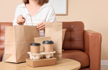 Fototapeten Musik Woman unpacking takeaway food and coffee delivery in brown paper bags and cardboard containers at home, convenience of modern food services and the comfort of enjoying meals at home  © Pixel-Shot