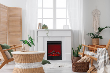 Obraz premium Cozy living room interior with modern fireplace, wicker furniture, and green houseplants for home comfort and relaxation