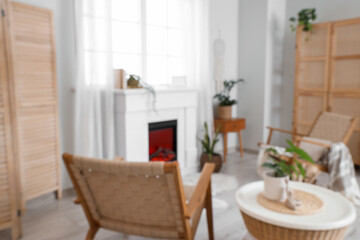 Obraz premium Cozy living room interior with fireplace, modern furniture, and green houseplants for home comfort and relaxation