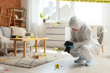 Forensic investigator documenting crime scene evidence with camera in living room, yellow tape...