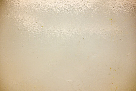 Close-up of a glossy painted wall surface with subtle imperfections and reflective texture.