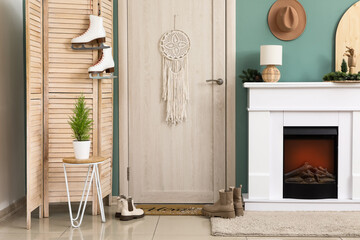 Obraz premium Interior of hallway with door, fireplace and winter shoes