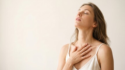 Fototapeta premium Young woman with eyes closed and hand on chest, finding peace and relaxation.