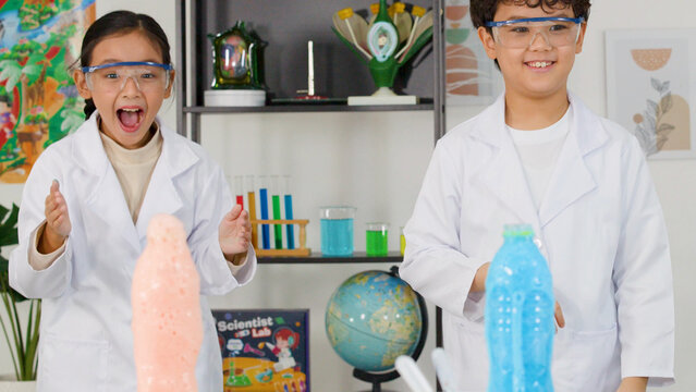 Excited Children in Lab Coats Watching Colorful Foam Science Experiment