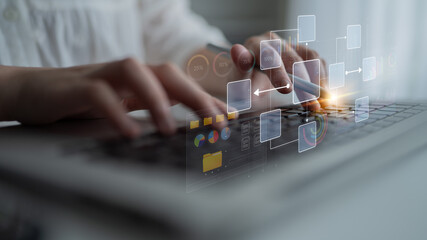 Hands Typing on a Keyboard with Digital Flowcharts and Data Visualizations to Illustrate Modern Technology and Collaborative Work Processes. Bitwise. © InfiniteFlow