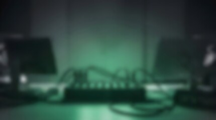 Naklejka premium Cinematic blurred server room background, dark green glowing data center equipment, abstract technology network hub with cables and monitors