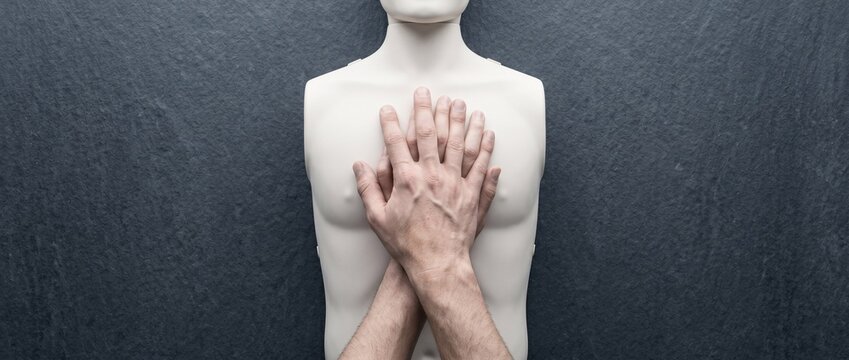 Top view of hands performing CPR chest compressions on a medical training mannequin
