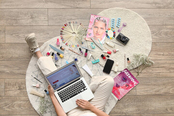Naklejka premium Woman on floor with laptop, beauty products, and fashion magazines, online shopping and self-care lifestyle