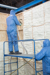 Fototapeta premium Foam is applied to the walls to warm the house