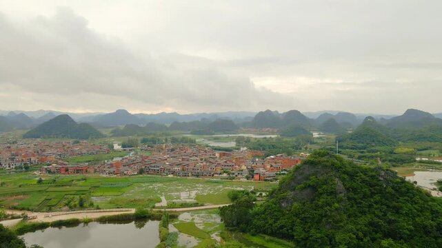 Panoramic Karst Mountains, Town, and Green Valley Landscape