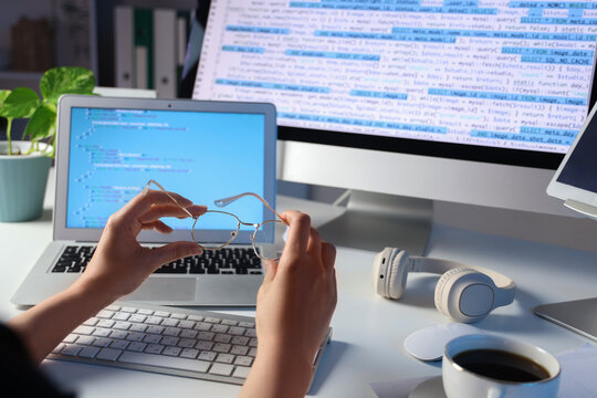 Female programmers hands with eyeglasses at table in office, closeup