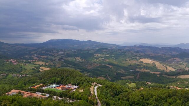 Aerial wide shot heading west from San Marino into Italian countryside