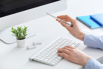 Fototapeta premium Professional businesswoman working on computer with pen and keyboard, modern office workspace productivity, the scene emphasizes productivity and digital communication