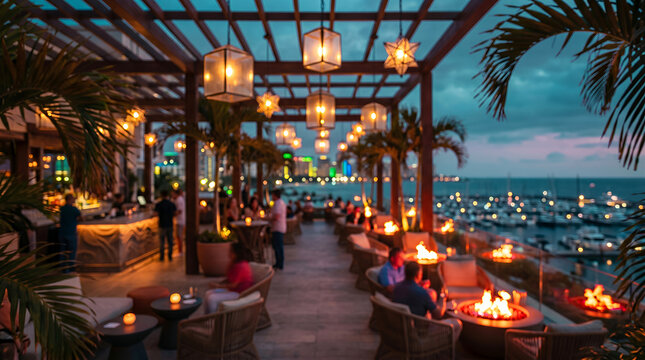 Rooftop restaurant at dusk with ocean view, fire pits, and city lights terrace patio