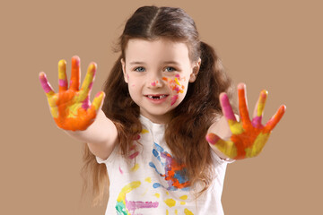 Obraz premium Happy young girl with paint-covered hands and face, creative childhood playtime, art and craft activity