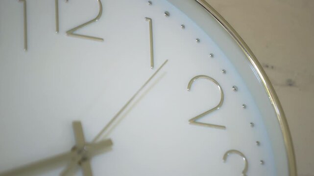 A close-up of the hand on a wall clock showing the time